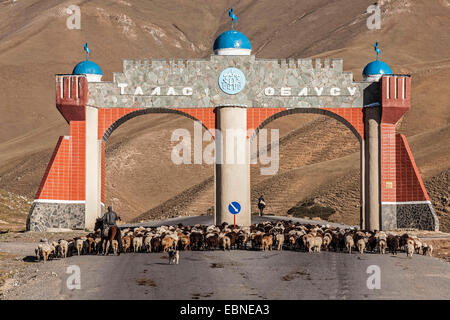 Troupeau de moutons sur la route avec monument, Kirghizistan, Djalalabad, Taskoemuer Banque D'Images