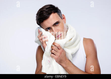 Portrait d'un homme avec son visage de séchage serviette sur fond gris Banque D'Images