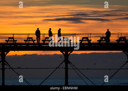 Aberystwyth, Pays de Galles, Royaume-Uni. 3 Décembre, 2014. Météo France : une belle côte ouest coucher de soleil sur la mer à mesure que les gens se rassemblent pour profiter de la vue et de s'interroger sur les milliers d'étourneaux venant se percher sur le Royal Pier. Credit : atgof.co/Alamy Live News Banque D'Images