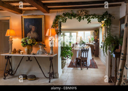 Table console recouvert de marbre avec paire de candélabres lampes dans hall d'entrée avec plafond à poutres apparentes et 18e siècle cadre doré Banque D'Images