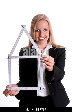 Femme avec règle de pliage en forme d'une maison Banque D'Images