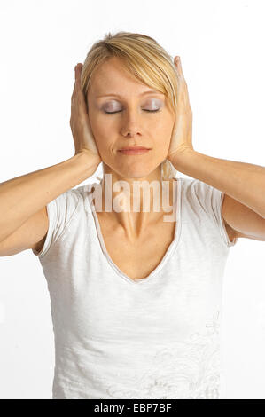 Jeune femme détendue avec les yeux fermés est de garder ses oreilles fermer Banque D'Images