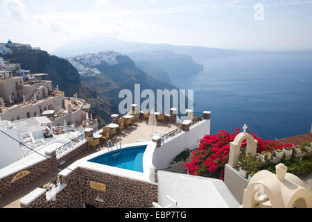 Imerovigli, Santorini, sud de la mer Egée, en Grèce. Vue vers le sud le long de la caldeira, l'agréable terrasse et piscine en premier plan. Banque D'Images