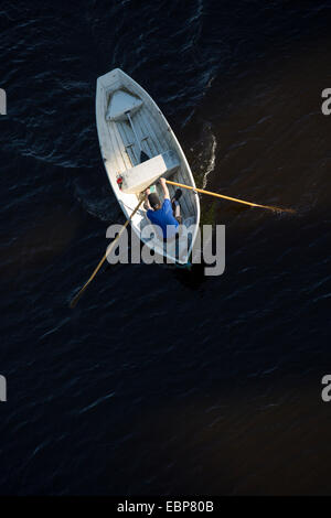 Vue aérienne d'un homme ramer un barque en fibre de verre / skiff / canot pneumatique , Finlande Banque D'Images
