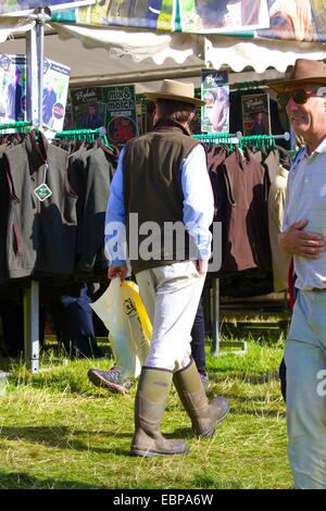 Homme marchant passé étals de vêtements. Lowther Show, Lowther Estate, Lowther, Penrith, Cumbria. Banque D'Images