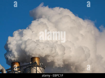 Nuages de fumée d'une cheminée sur fond de ciel bleu. Banque D'Images