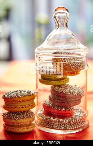 Macaron pétillant les cookies dans un bocal en verre pour les fêtes nappe orange Banque D'Images