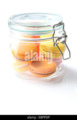 Les macarons dans un bocal en verre sur un fond blanc Banque D'Images