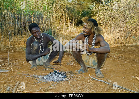 Deux bushmen Hadzabe au coin de la cheminée, la Tanzanie, le lac Eyasi, Serengeti Banque D'Images