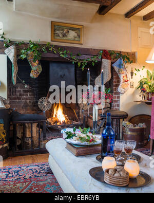 Sherry et mince pies disposés sur pouf en salon avec cheminée originale Banque D'Images