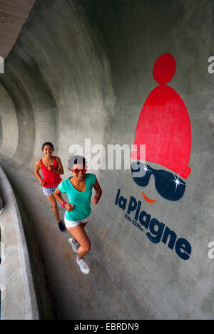 Deux jeunes femmes s'exécutant sur la piste de bobsleigh en été, France, Savoie, La Plagne Banque D'Images