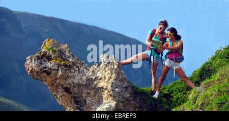 Deux jeunes femmes Missionnés sur un éperon rocheux en regardant une carte, France, Savoie, parc national de la Vanoise Banque D'Images