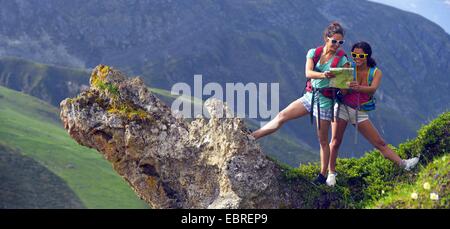 Deux jeunes femmes Missionnés sur un éperon rocheux en regardant une carte, France, Savoie, parc national de la Vanoise Banque D'Images