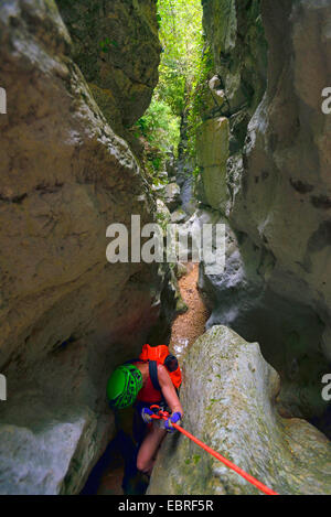 Rappeling femme dans une gorge étroite, le canyoning dans le canyon sec de Venascle, France, Provence, Verdon, Parc naturel régional du Verdon Banque D'Images