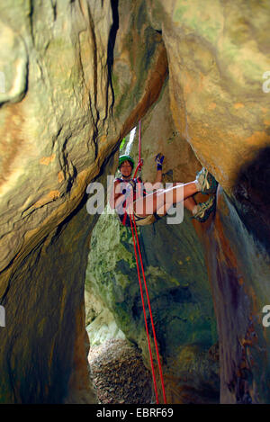 Rappeling femme dans une gorge étroite, le canyoning dans le canyon sec de Venascle, France, Provence, Verdon, Parc naturel régional du Verdon Banque D'Images