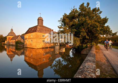 Château à douves Westerwinkel avec deux cyclistes, l'Allemagne, en Rhénanie du Nord-Westphalie, Ascheberg Banque D'Images