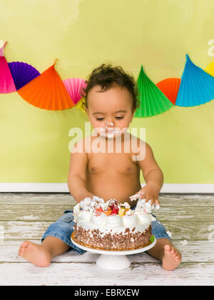 Adorable bébé africain lors d'un smash de gâteau sur son premier anniversaire Banque D'Images