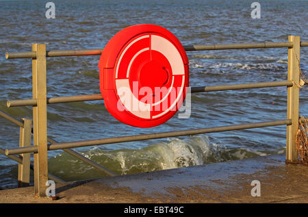 La côte est du Kent - Angleterre - Baie Minnis, bouée rouge vif attaché à une clôture métallique sur la promenade avec vue sur la mer à marée haute Banque D'Images