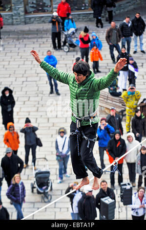 Homme marchant sur une slackline highline en face de nombreux spectateurs vers le bas dans l'allée, France, Savoie, Val-dAEIsÞre Banque D'Images