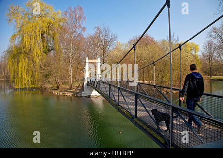 Man with dog marche sur la passerelle pour piétons 'Mattenklodtsteg' sur la rivière Lippe , l'Allemagne, en Rhénanie du Nord-Westphalie, Lippstadt Banque D'Images