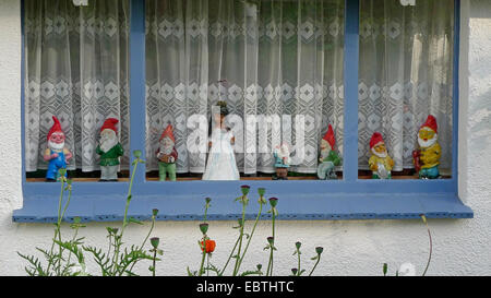 La figure de blanche neige et les sept nains de jardin en une ligne dans la fenêtre d'une maison d'été, Allemagne Banque D'Images