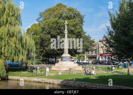 Monument commémoratif de guerre avec les gens de vous détendre sur une journée ensoleillée Bourton-on-the-Water les Cotswolds Gloucestershire Banque D'Images