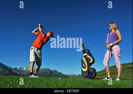 Jeune couple en jouant au golf, France, Savoie Banque D'Images