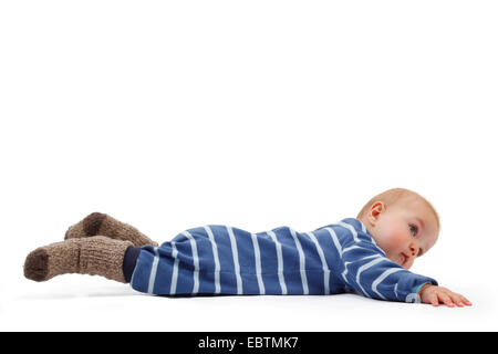 Little Boy wearing barboteuse à rayures sur le sol Banque D'Images