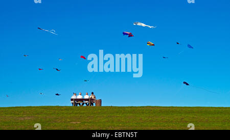 Quatre personnes assis sur un banc à endiguer et à l'Allemagne, à des cerfs-volants, Basse-Saxe, Cuxhaven, Otterndorf Banque D'Images