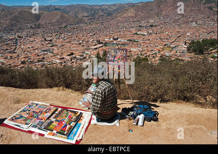 Artiste assis sur une pente avec vue sur la ville et la peinture, Pérou, Cusco Banque D'Images