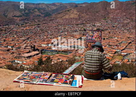 Artiste assis sur une pente avec vue sur la ville et la peinture, Pérou, Cusco Banque D'Images