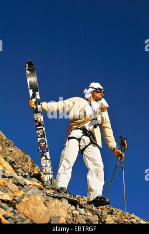 Skieur freeride déguisé en aventurier suranné, debout sur pente rocheuse Banque D'Images