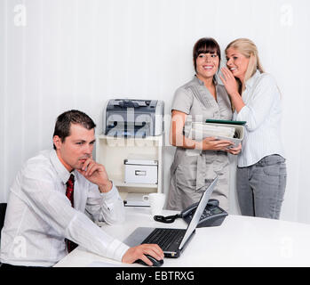 L'intimidation dans un bureau, deux femmes rire à un homme Banque D'Images