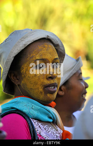 Femme à la peau sombre visage peint en jaune, Madagascar Banque D'Images