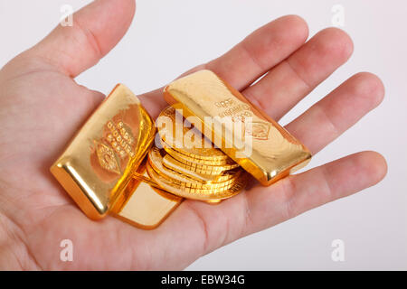 La barre d'or pièces d'or dans une main Banque D'Images