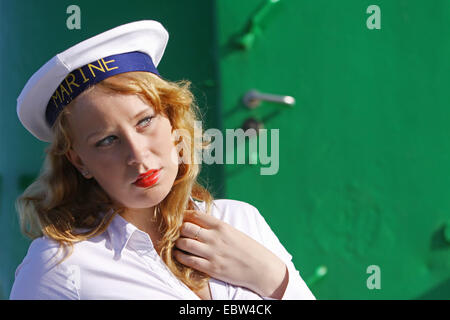 Jeune femme rousse avec capuchon marin en face de la porte verte, l'Allemagne, Mecklembourg-Poméranie-Occidentale Banque D'Images