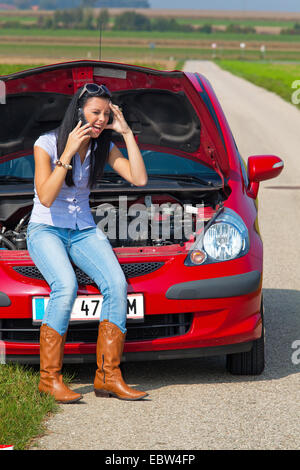 Jeune femme avec panne de voiture faites un appel téléphonique Banque D'Images