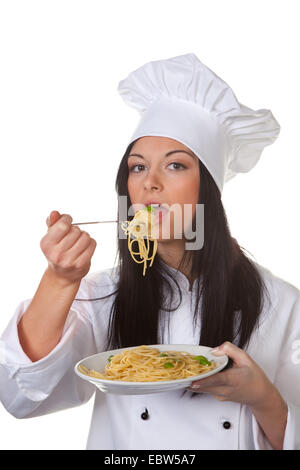 Jeune femme cuisinière est mange du spaghetti Banque D'Images