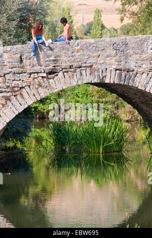 Couple sur un pont de pierre la pêche avec un angle, l'Espagne, Navarre, Pays Basque, Trinidad de Arre, bask. Villava Banque D'Images