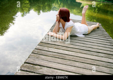 Young woman lying on boardwalk, Allemagne, Brandebourg Banque D'Images