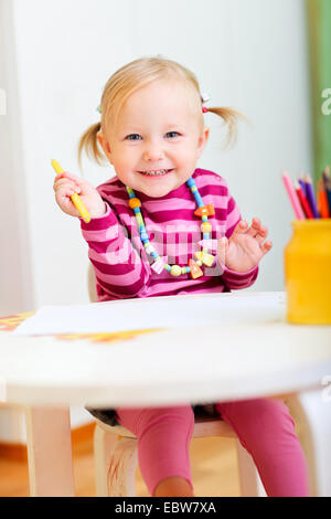 Une petite fille dessin avec des crayons de couleur Banque D'Images