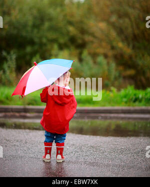 Vue de derrière une petite fille avec un parapluie Banque D'Images