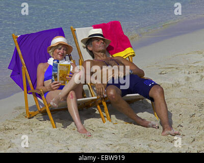 Couple de personnes âgées se trouvant dans la région de chaises en toile sur plage de sable fin, Baléares, Ibiza Banque D'Images