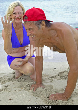 Couple de personnes âgées sur la plage, l'homme faire pressups, la femme compte, Baléares, Ibiza Banque D'Images