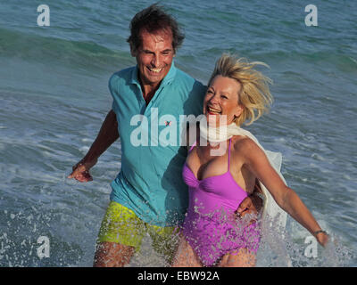 Couple de personnes âgées sur la plage en cours d'exécution par l'eau, Baléares, Ibiza Banque D'Images