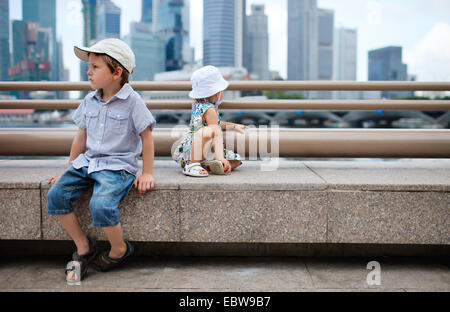 Deux petits enfants assis en centre-ville, Singapour, Singapour