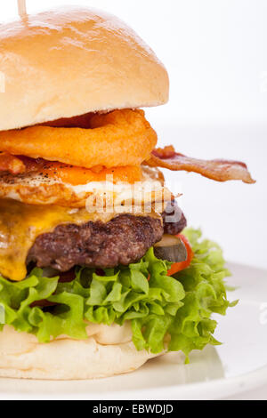 Delicious egg and bacon cheeseburger avec un remplissage de la nutrition des ingrédients de la salade, un fromage, Patty de boeuf haché, œuf frit et bacon croustillant sur un rouleau croustillant blanc Banque D'Images