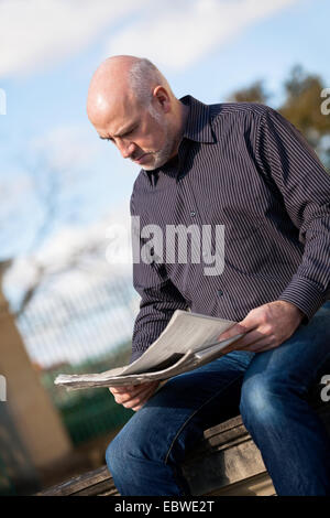 Confiant d'âge moyen attrayant homme debout en attente dans une voie rurale avec bras croisés à la recherche de la droite de la Fra Banque D'Images