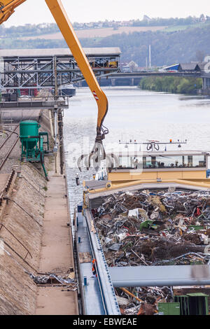 Barge ouverte d'être chargé ou déchargé à un quai sur un canal urbain ou d'une rivière par une grue industrielle à usage intensif Banque D'Images