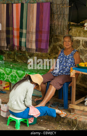 Le laotien Woman Getting Massage des pieds, Luang Prabang, Laos Banque D'Images